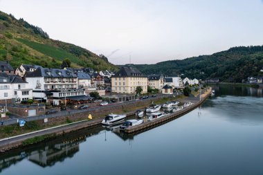 Breathtaking summer view of Castle Cochem, featuring charming houses and boats along the serene Moselle River. clipart