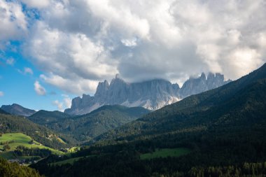 İtalyan Alpleri 'nin çarpıcı güzelliğini keşfedin, yemyeşil vadiler ve dramatik bulut oluşumları altında yükselen dağlar..