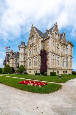 İspanya, Santander 'de bulutlu bir gökyüzüne karşı, çiçeklerle süslenmiş tarihi bir malikanenin çarpıcı manzarası..