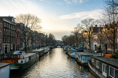 Amsterdam kanallarının manzarası, yüzen yüzen yüzen yüzen evler ve gün batımında yıkanan güzel mimari..