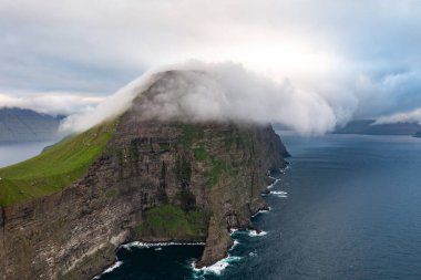 Faroe Adaları 'nın nefes kesen güzelliğini sisle örtülü bu büyüleyici uçurum görüntüsüyle yaşayın..