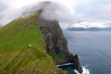 Engebeli Faroe Adaları kayalıklarının sergilenen serin yeşil ve okyanus dalgaları sonbahardan hemen önce çekildi..