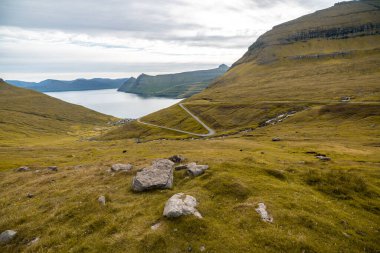 Faroe Adaları 'nın çarpıcı manzarası, yemyeşil tepeler ve sakin sular, seyahat ve doğa meraklıları için mükemmel..