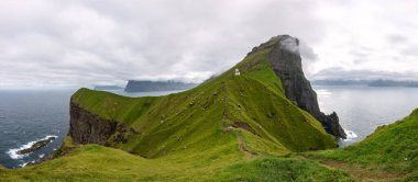 Yaz sonunda Faroe Adaları 'nın nefes kesen panoramik manzarası yemyeşil kayalıklar ve sakin suları gözler önüne seriyor..