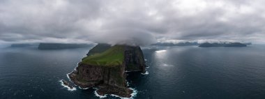 Faroe Adaları 'nın çarpıcı hava manzarası dingin okyanus üzerinde dramatik uçurumlar ve yaz bulutları sergiliyor. Seyahat ve doğa temaları için mükemmel..