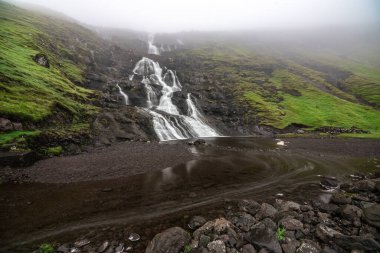 Yazın sonlarında yemyeşil ve sisli tepelerle çevrili Faroe Adaları 'ndaki çarpıcı şelalenin güzelliğini yakala..