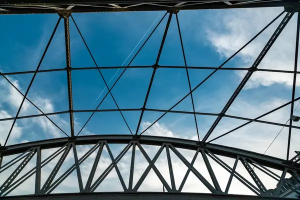 Güneşli bir yaz gününde Hamburg köprüsünün altındaki karmaşık çelik ve gökyüzü desenlerini keşfedin..