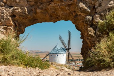 Yazın çarpıcı bir kaya kemeri tarafından çerçevelenen ikonik Consuegra yel değirmenlerini keşfedin. Kültür ve doğanın mükemmel bir karışımı..