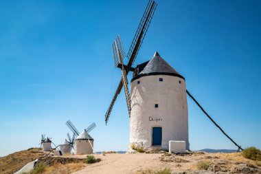 Güneşli bir yaz gününde İspanya 'daki ikonik Consuegra Değirmenlerini keşfedin, Don Kişot' un mirasını tekrarlayın..