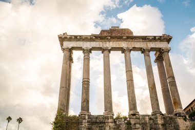 Roma 'nın zengin tarihini gözler önüne seren mavi gökyüzü altındaki antik Roma sütunlarının çarpıcı manzarası..