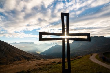 Büyüleyici bir manzara, büyüleyici İtalyan Alpleri 'nde canlı bir günbatımı arkaplanı olan bir haç silueti..