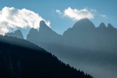 Sis ve güneş ışığıyla örtülü muhteşem Alpler manzarası doğa aşıkları ve macera meraklıları için mükemmel..