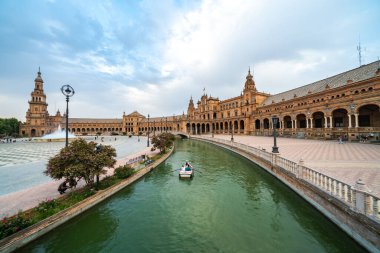 İspanya, Sevilla 'daki Plaza de Espaa' nın nefes kesici manzarası. Bu pitoresk alan huzurlu bir kanal, çarpıcı bir mimari ve huzurlu tekne anlarını içeriyor..