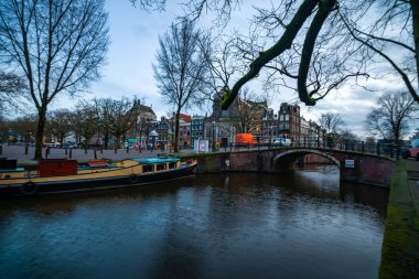Amsterdam 'daki büyüleyici kanal manzarası tarihi binalar ve sakin sular sergiliyor. Hollanda kültürünün mükemmel bir temsili.