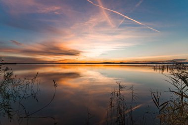 Albufera Gölü 'nde nefes kesici bir günbatımı manzarası sakin sulara yansıyan canlı renkler sergiliyor..