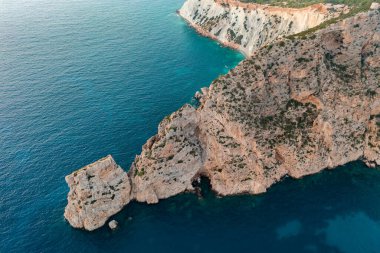 İbizas kıyı şeridinin engebeli kayalıklarını ve turkuaz sularını çeken çarpıcı hava manzaralı fotoğraf..