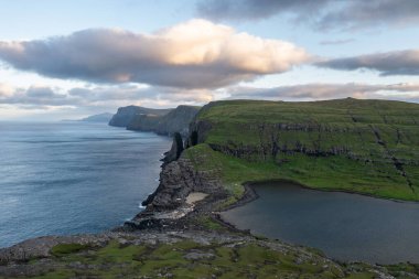 Faroe Adaları 'nın dramatik uçurumlarını ve dingin sularını yakalamak için nefes kesici drone çekimi, seyahat ve doğa meraklıları için mükemmel..