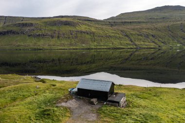 Sersemletici hava görüntüsü Faroe Adaları 'nın sakinliğini sakin suda canlı yansıtıyor..