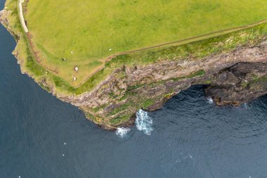Yazın sonlarında Faroe Adaları 'nın kayalıklarını ve denizini yakalayan nefes kesici bir dron atışı. Seyahat ve doğa projeleri için mükemmel..