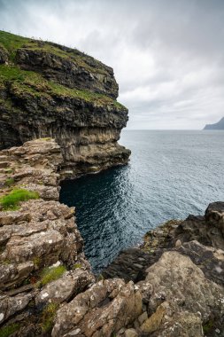 Faroe Adaları 'nın nefes kesici uçurumlarını yakalayın. Doğa fotoğrafçılığı ve seyahat meraklıları için mükemmel. Huzurlu bir sahil kaçışı.