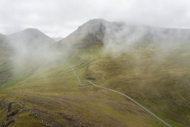 Faroe Adaları 'nın çarpıcı hava manzarası yemyeşil tepeleri ve dolambaçlı yolları sergiliyor..