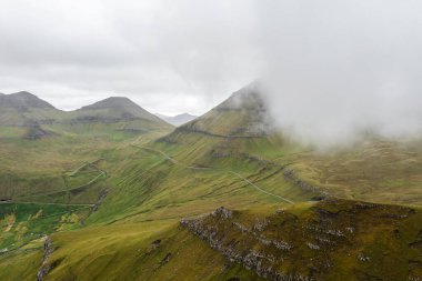 Yazın sonunda Faroe Adaları 'ndaki canlı yeşil dağların çarpıcı hava manzarası. Gösteriş için biçilmiş kaftan güzellik.