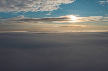 Gün batımında Faroe Adaları 'nın büyüleyici panoramik manzarası, aşağıdaki bulutlar ve yukarıdaki sakin gökyüzü. Seyahat ve doğa meraklıları için mükemmel..