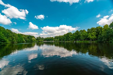 Kendinizi bu sakin yaz sahnesine daldırın. Almanya, Hamburg 'da sakin bir gölün güzelliğini hayret verici yansımalarla sergileyin..