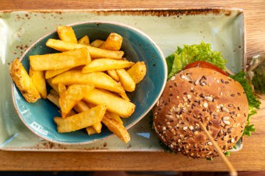 Ağız sulandıran burgerin tadını çıkarın. Kızarmış patatesle birlikte. Hamburg, Almanya 'da yaz yemeği için mükemmel..