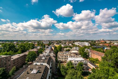 Hamburg 'un canlı bir yaz manzarası, parlak mavi gökyüzüne karşı şehrin siluetini ve yemyeşil manzarasını gözler önüne seriyor..