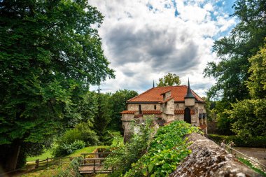 Güneşli bir yaz gününde yemyeşil yemyeşil çevrili büyüleyici bir Alman şatosunun manzarası..