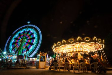 Turia Park 'taki canlı gece hayatını deneyin. Renkli ışıklarla aydınlatılmış çarpıcı bir dönme dolap ve atlıkarınca..