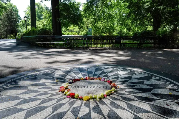 stock image The famous place, Flowers and Memorbilia are laid around John Lennons memorial at Central Parks Strawberry Fields on October 10, 2010 in New York City. High quality photo