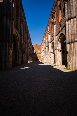 Abbazia di San Galgano 'nun çatısı olmadan duvarları gökyüzünde bir haç oluşturur.