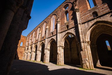 Abbazia di San Galgano 'nun çatısı olmadan duvarları gökyüzünde bir haç oluşturur.