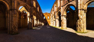 Abbazia di San Galgano 'nun çatısı olmadan duvarları gökyüzünde bir haç oluşturur.