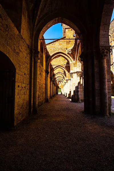 Abbazia di San Galgano 'nun çatısı olmadan duvarları gökyüzünde bir haç oluşturur.