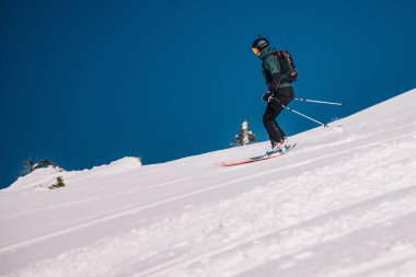 Karpaty, Ukraine, February 8, 2023. Skiers and snowboarders freeride in clear sunny weather on the slopes of the mountains near the resort of Dragobrat. High quality photo