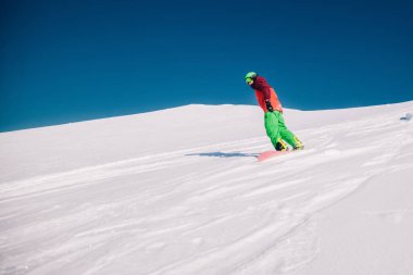 Karpaty, Ukraine, February 8, 2023. Skiers and snowboarders freeride in clear sunny weather on the slopes of the mountains near the resort of Dragobrat. High quality photo