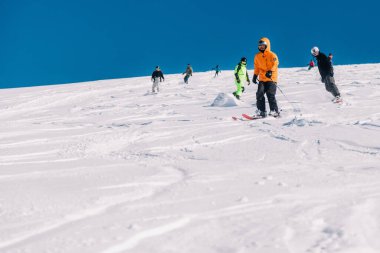 Karpaty, Ukraine, February 8, 2023. Skiers and snowboarders freeride in clear sunny weather on the slopes of the mountains near the resort of Dragobrat. High quality photo