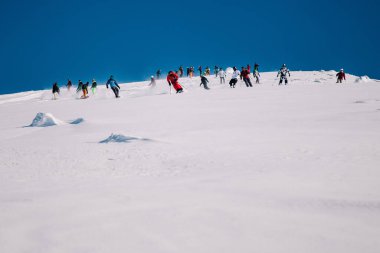 Karpaty, Ukraine, February 8, 2023. Skiers and snowboarders freeride in clear sunny weather on the slopes of the mountains near the resort of Dragobrat. High quality photo