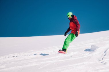 Karpaty, Ukraine, February 8, 2023. Skiers and snowboarders freeride in clear sunny weather on the slopes of the mountains near the resort of Dragobrat. High quality photo
