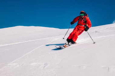 Karpaty, Ukraine, February 8, 2023. Skiers and snowboarders freeride in clear sunny weather on the slopes of the mountains near the resort of Dragobrat. High quality photo