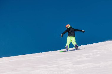 Karpaty, Ukrayna, 8 Şubat 2023. Kayakçılar ve snowboardcular, Dragobrat tatil beldesi yakınlarındaki dağların yamaçlarında açık güneşli havada serbest dolaşırlar. Yüksek kalite fotoğraf