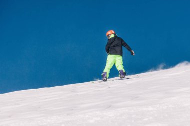 Karpaty, Ukrayna, 8 Şubat 2023. Kayakçılar ve snowboardcular, Dragobrat tatil beldesi yakınlarındaki dağların yamaçlarında açık güneşli havada serbest dolaşırlar. Yüksek kalite fotoğraf