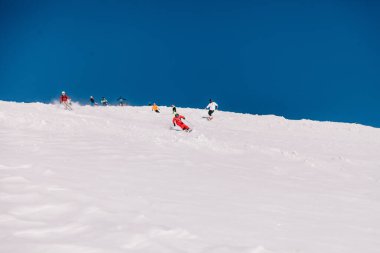 Karpaty, Ukraine, February 8, 2023. Skiers and snowboarders freeride in clear sunny weather on the slopes of the mountains near the resort of Dragobrat. High quality photo