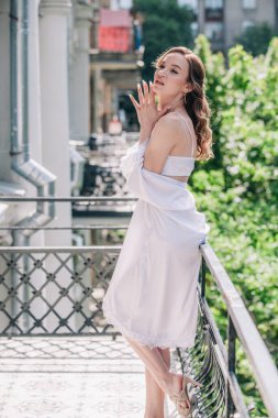 Genç, narin, güzel gelin sabah düğün balkonda güzel beyaz dantelli iç çamaşırlarıyla dikilmeden önce. Yüksek kalite fotoğraf