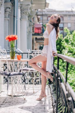 Genç, narin, güzel gelin sabah düğün balkonda güzel beyaz dantelli iç çamaşırlarıyla dikilmeden önce. Yüksek kalite fotoğraf