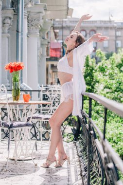 Genç, narin, güzel gelin sabah düğün balkonda güzel beyaz dantelli iç çamaşırlarıyla dikilmeden önce. Yüksek kalite fotoğraf