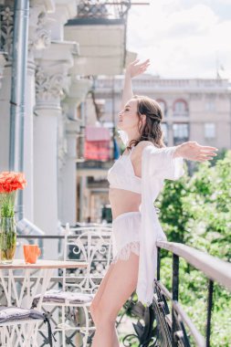 Genç, narin, güzel gelin sabah düğün balkonda güzel beyaz dantelli iç çamaşırlarıyla dikilmeden önce. Yüksek kalite fotoğraf